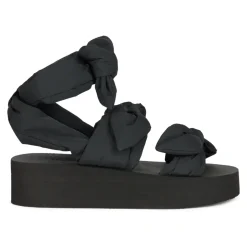 Moderne sort sandal med plateau og omsluttende rem.