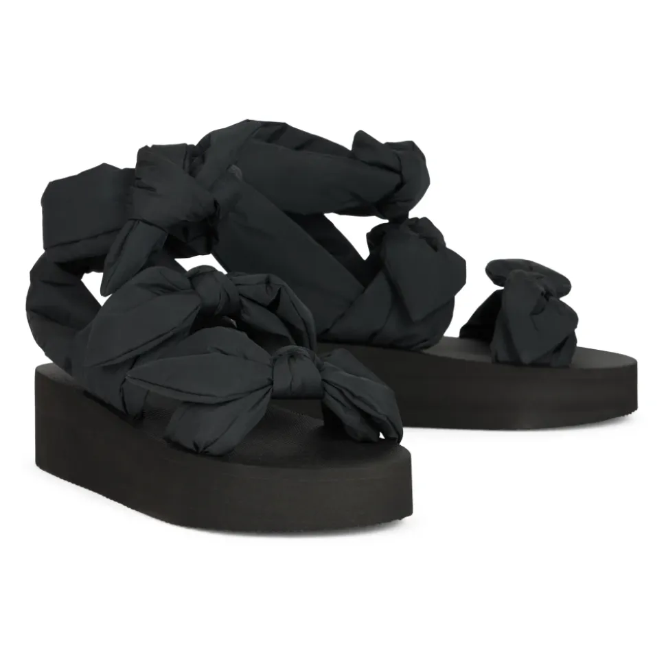Moderne sort sandal med plateau og omsluttende rem.