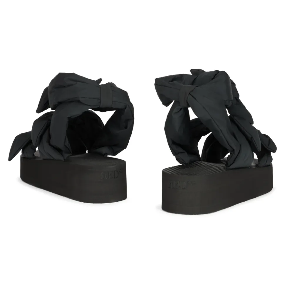 Moderne sort sandal med plateau og omsluttende rem.