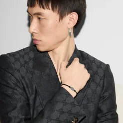 Varemærkearmbånd i sterlingsølv og sort læderrem med oval mærke